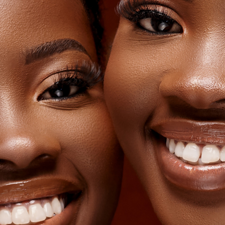 A personal portrait by Quintessence Photography UK. Two ladies with makeup and shiny white toothy smiles.
