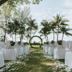 Destination Wedding Location by the beach, decorated chairs with white chair covers and palm trees in the background