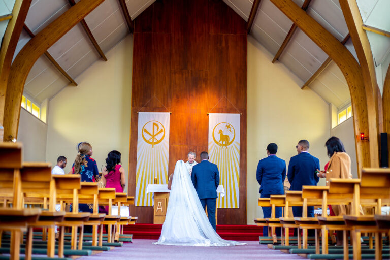 Wedding Photoshoot by Quintessence Photography UK. The bride and groom take their wedding vows at the altar.